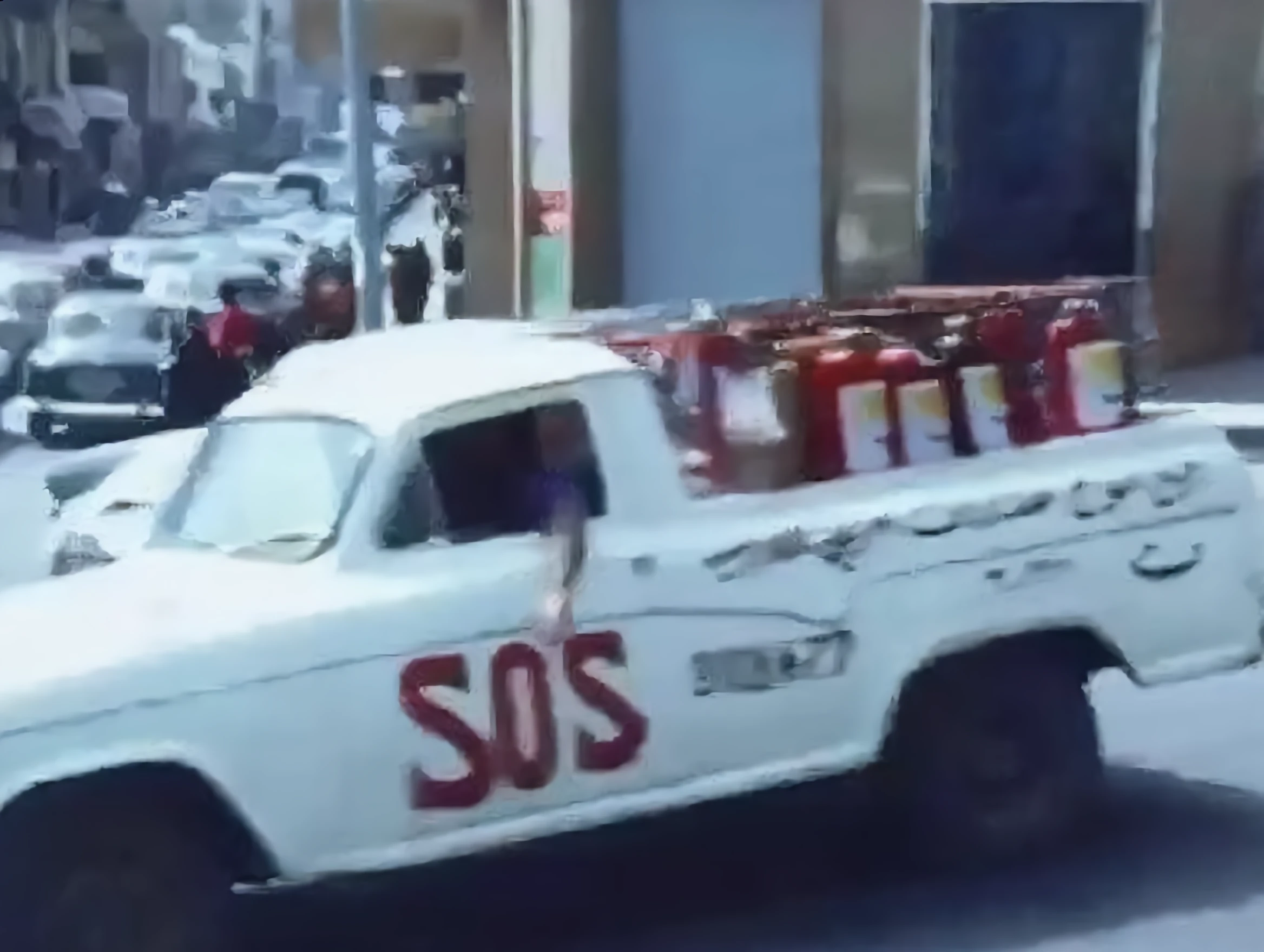 The S.O.S pickup loaded with fire extinguishers driving through 1960s Beirut
